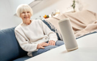 Senior woman sitting on couch looking at smart device