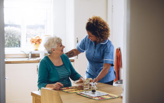 Senior woman receiving food from caregiver in senior living community