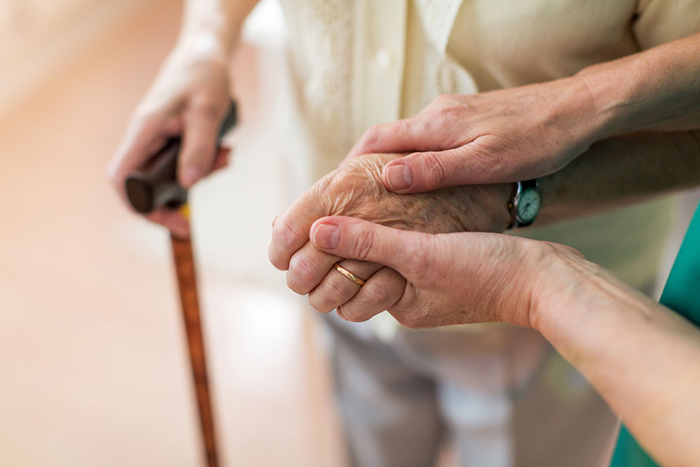 Senior hands holding caregivers hands