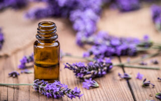 Lavender tincture with lavender spread around on table, essential oils