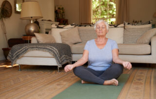 A senior woman practices meditation at home