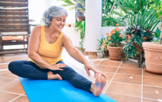 A senior woman stretches her leg to prevent falls