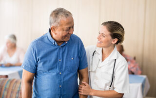 A senior man and a nurse go on a walk together