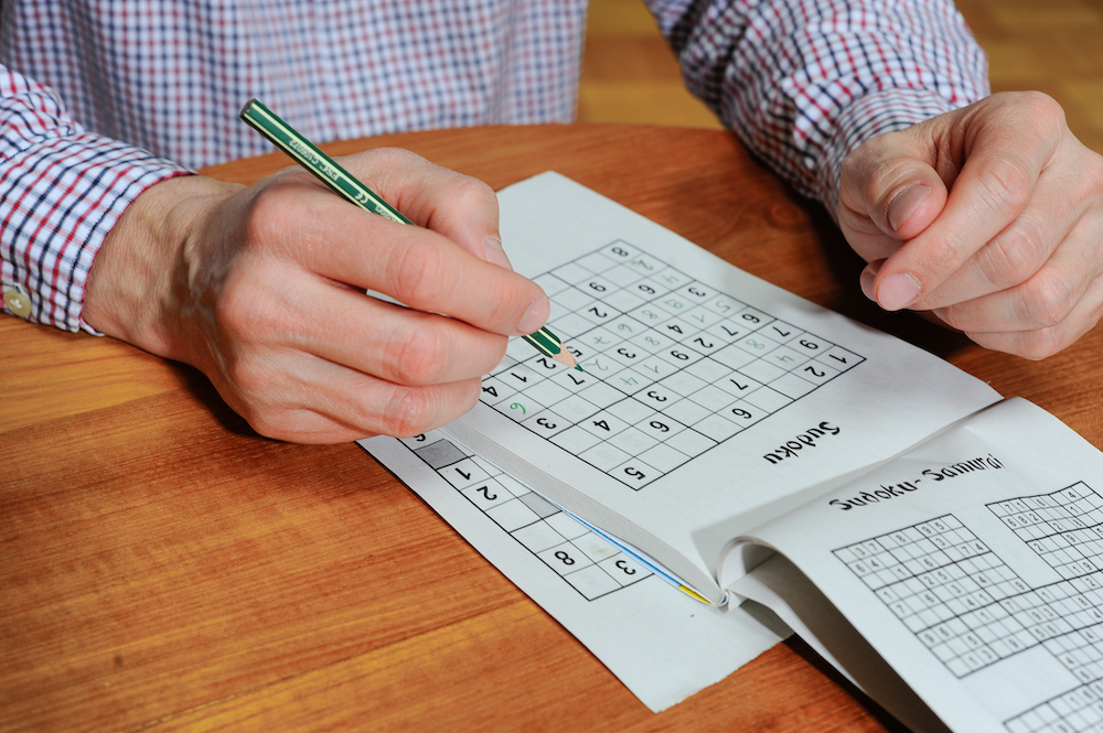 A senior man doing a Sudoku puzzle