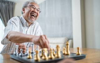 A happy senior man plays chess