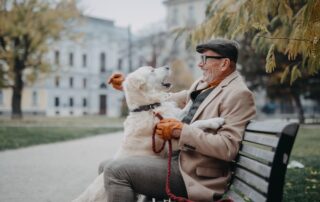 A happy senior man rests on a bench after walking his dog around the senior living in Canton, MI