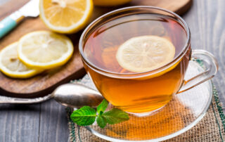 A cup of herbal mint tea with a lemon slice