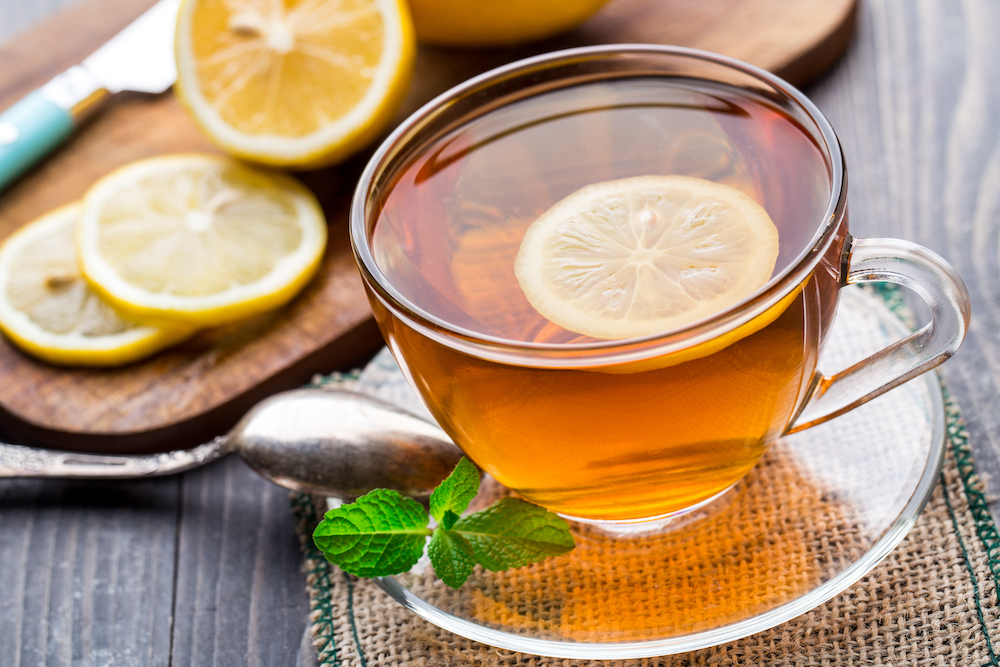 A cup of herbal mint tea with a lemon slice