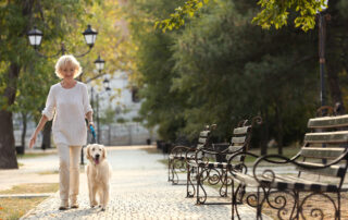 A senior woman walking her dog at the best memory care facilities near me