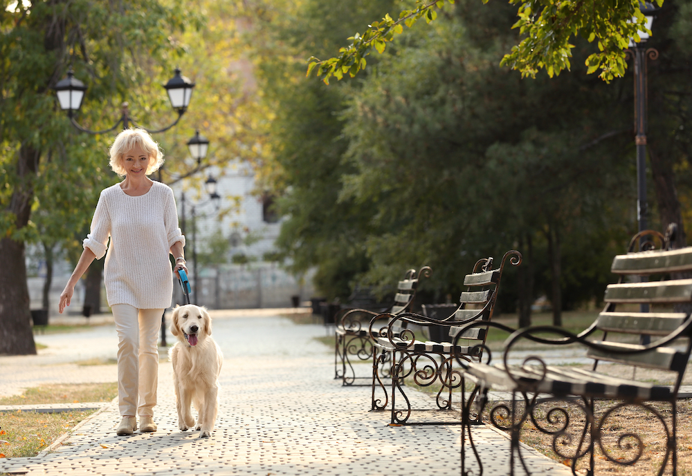 A senior woman walking her dog at the best memory care facilities near me