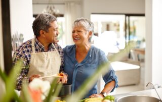 A happy senior couple cooks and prepares a meal together in assisted living facilities in Canton, MI.