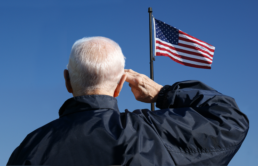 A senior veteran saluting an American flag