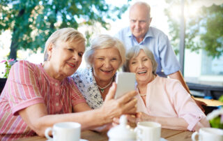 A group of senior friends drinking coffee and taking a selfie at one of the best senior living communities in MI