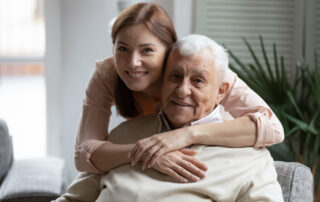 A young woman and her senior father share a hug