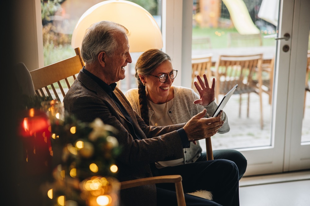 A senior man and daughter using a tablet to stay connected at a dementia senior living community