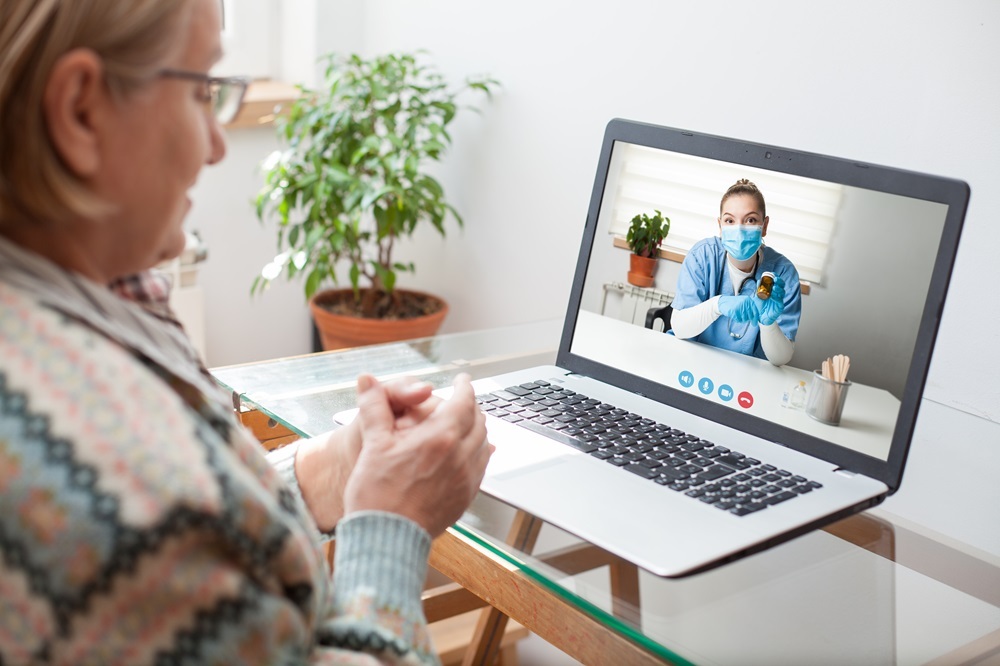 A senior living resident using a laptop for telehealth services