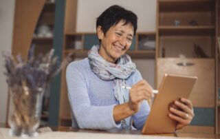 Senior woman inside her senior living communities talking to her loved one on a tablet.